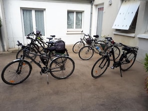 Bicycles parked outside a building with windows and a door. - Hôtel du Cerf (Château-Gontier-sur-Mayenne)