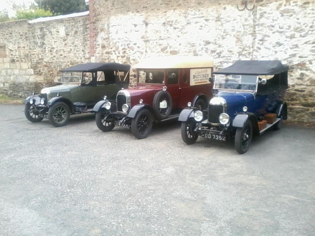 Tres coches antiguos aparcados en fila.