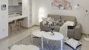 A modern living room with a high ceiling, a dining area, and a kitchen. - Tribear House 2 (Seoul)