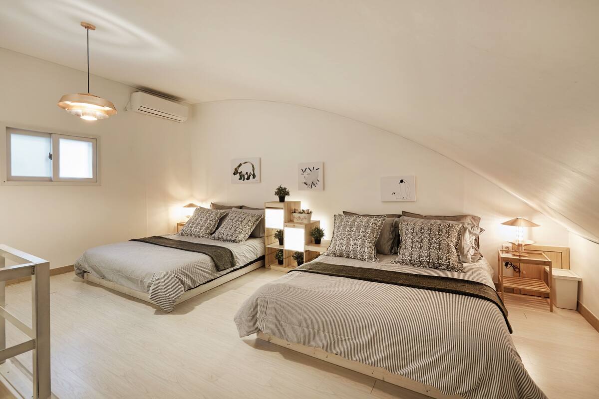 Ein Schlafzimmer mit zwei Betten, einem Fenster und einem Deckenventilator.