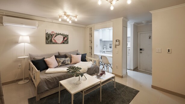 A modern living room with a sofa, coffee table, and a painting on the wall. - Tribear House 2 (Seoul)