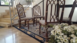 A staircase with a metal railing, a patterned rug, and a floral arrangement. - Villa Erry (Trani)