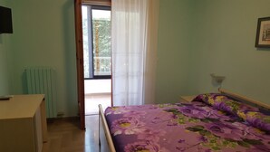 A bedroom with a bed, a desk, and a radiator. - Villa Erry (Trani)