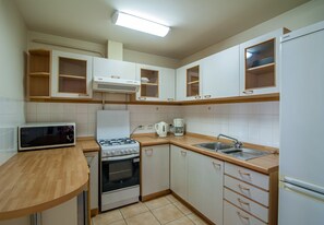 Kitchen features a microwave, gas stove, oven, and refrigerator, along with ample storage and cabinetry.