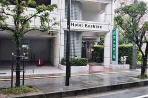 Hotel Koshien con fachada moderna, entrada con tejas y un letrero que indica que forma parte del complejo Hotel Koshien.