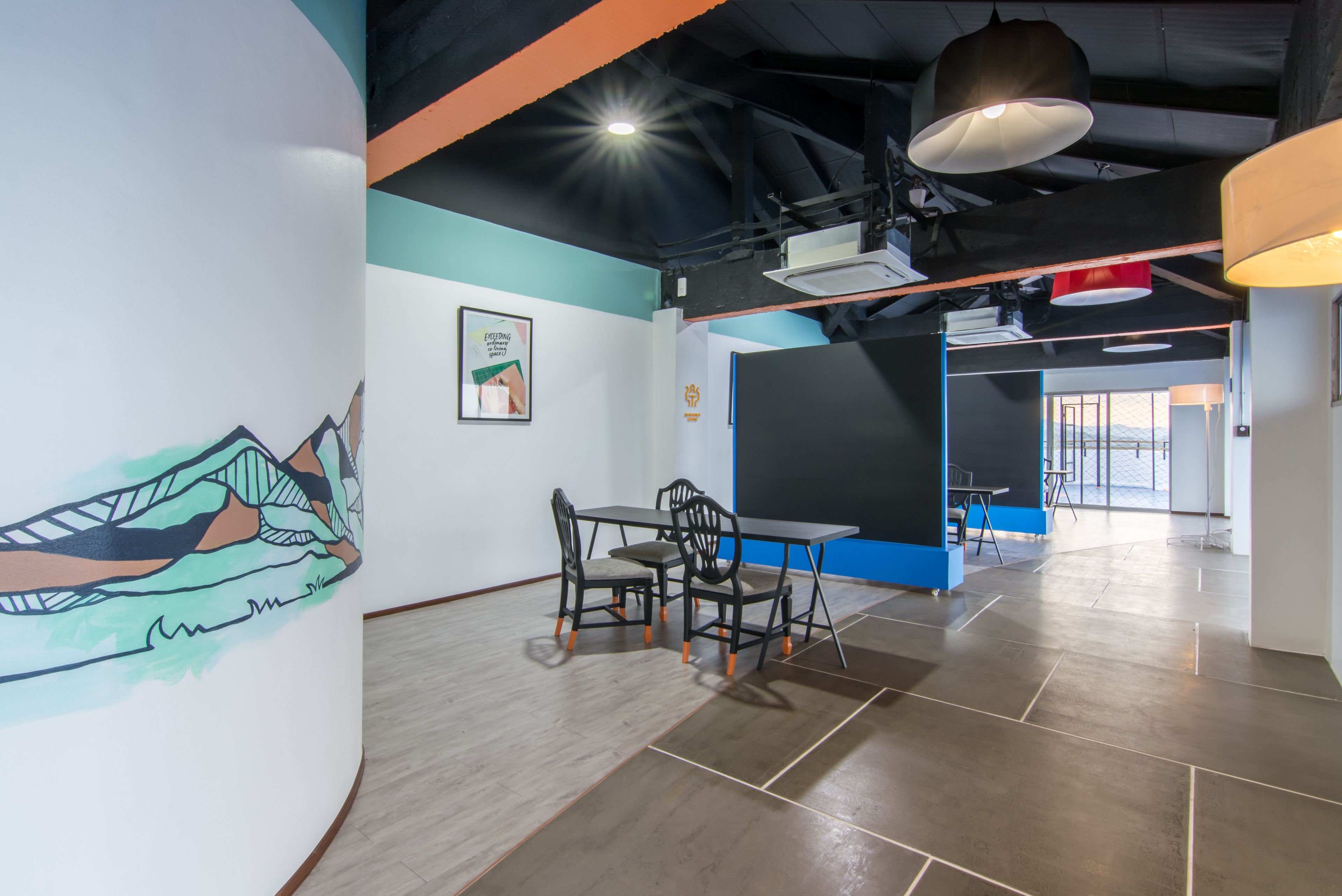 A modern interior with a dining area, a large wall mural, and a view of the outdoors.