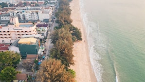 Vista aérea de una zona costera con playa, edificios y una carretera.