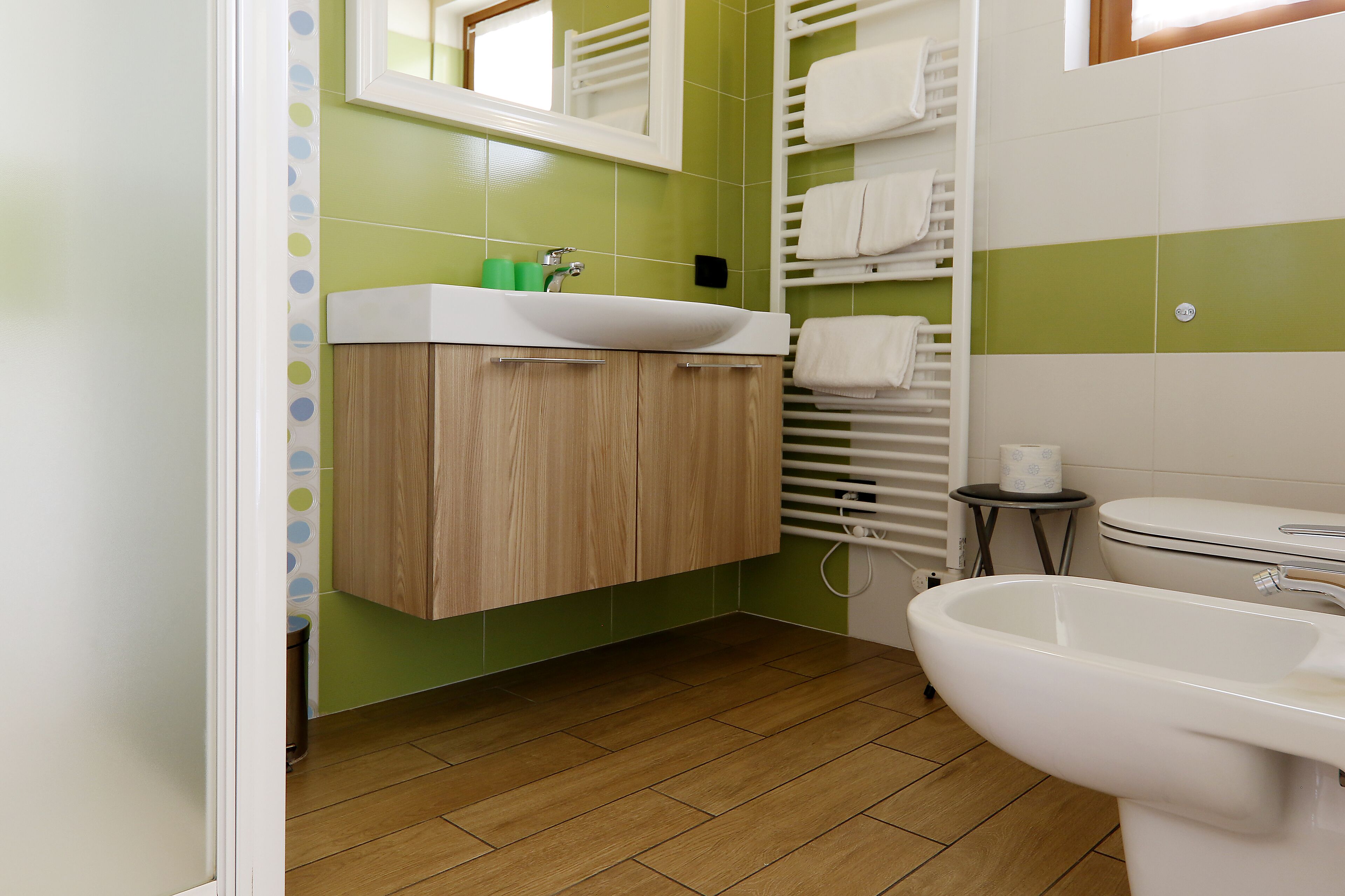 A bathroom with a wooden vanity, a sink, a toilet, and a bathtub.