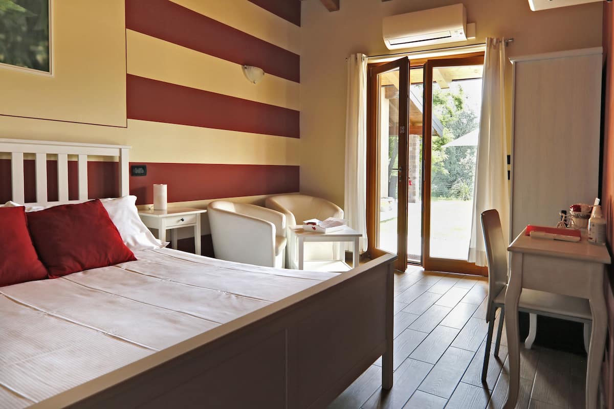 Een slaapkamer met een bed, een bureau en een stoel.