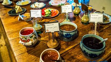 Une table où sont présentées différentes confitures et condiments faits maison, chacune étant étiquetée avec son nom.