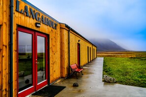 A wooden building with a red door and the name "LANGAHOLT" on the facade.