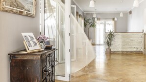 A hallway with a wooden cabinet, a framed picture, and a potted plant. - Hotel Gastronómico La Breña (Barbate)