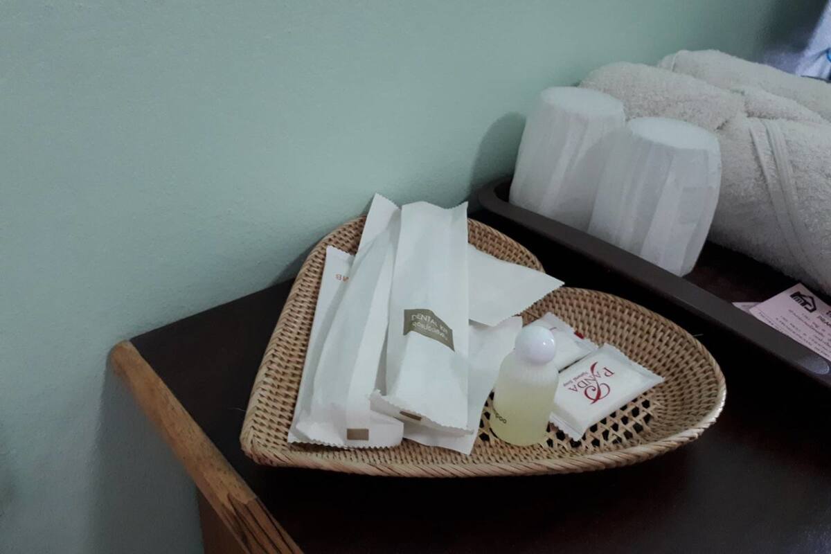 A tray with toiletries on a table in a room with a light green wall.