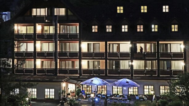 Een meerhoog gebouw met balkons en grote ramen, waarschijnlijk een hotel of resort.