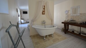 Un baño con una bañera independiente, un lavabo con espejo y una cortina de ducha.
