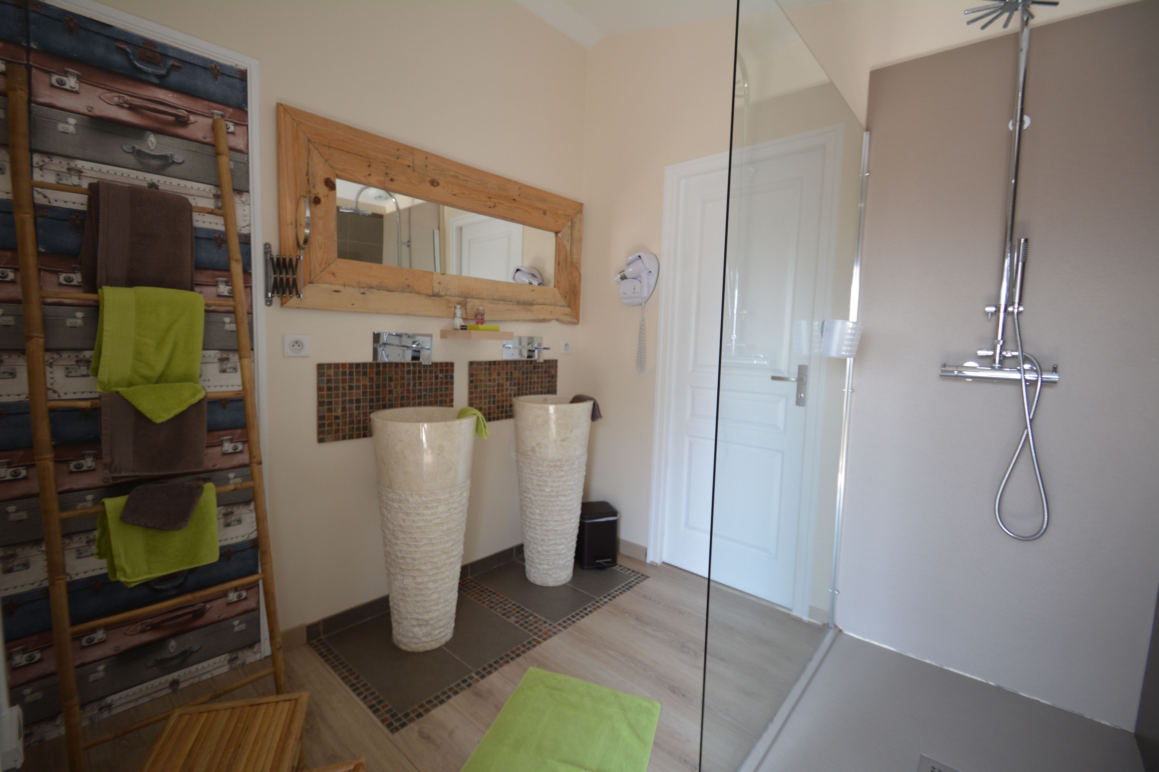 A bathroom with a wooden ladder, two large vases, a mirror, and a shower.