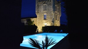 Un castillo de piedra con una piscina en primer plano.