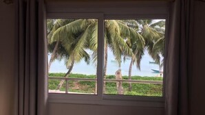 Una ventana con vista a palmeras y una masa de agua.