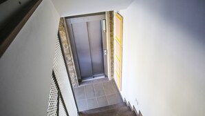 A staircase leading to a door with a textured wall and a tiled floor. - B&B WarmUp Grosseto (Grosseto)
