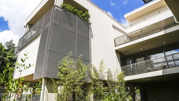 A modern building with a sloped roof, large windows, and a balcony with metal railings. - B&B WarmUp Grosseto (Grosseto)