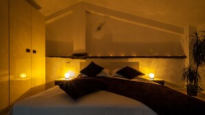 Une chambre à coucher avec un lit, des lampes de chevet, une table de chevet et une plante en pot.