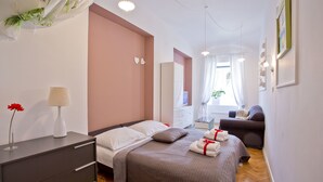 Un dormitorio moderno con una cama grande, mesitas de noche, un aparador y un rincón de estar con sofá.