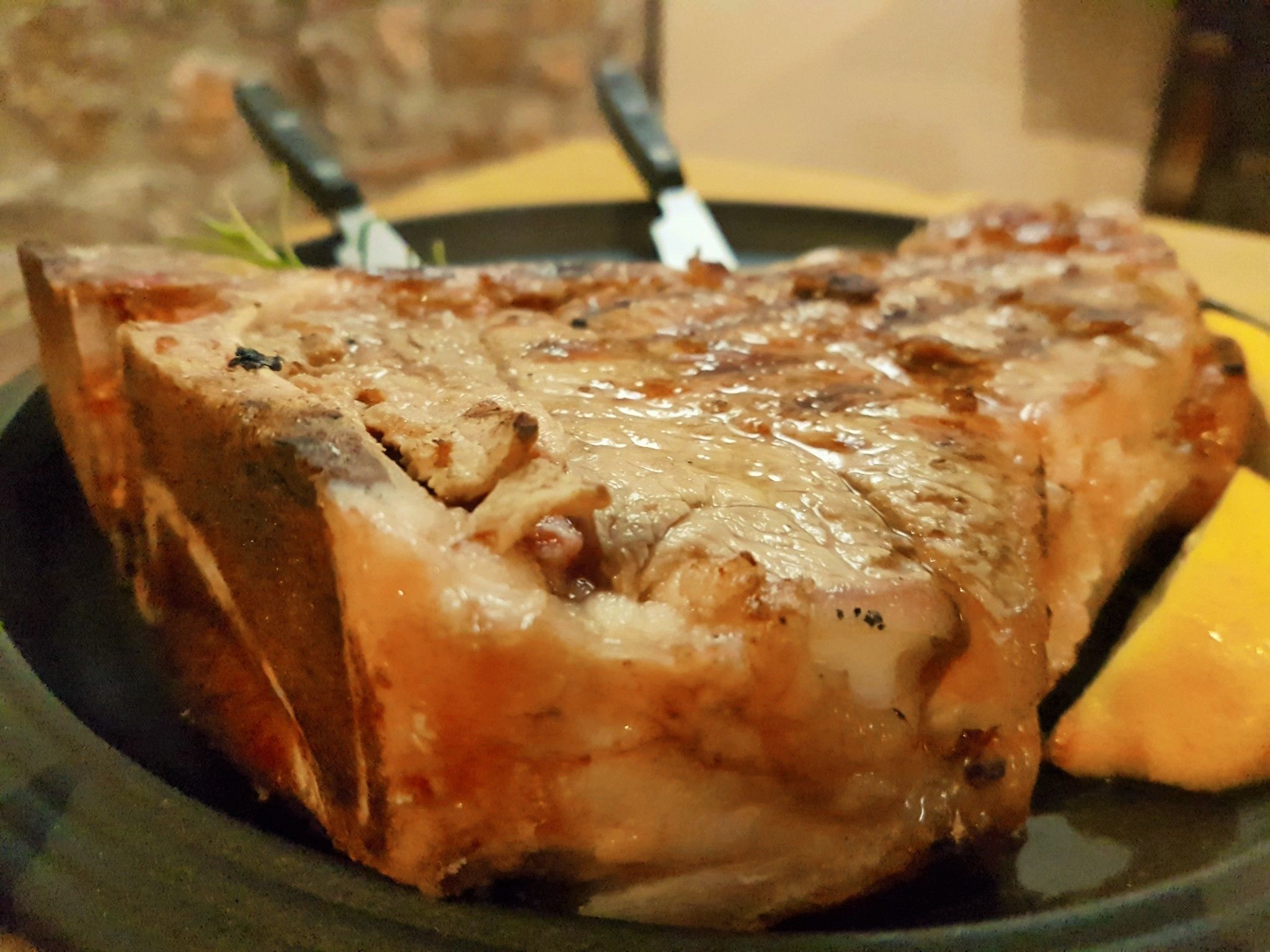 Un steak à la croûte brillante et caramélisée, servi dans une assiette sombre.