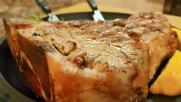 Un steak à la croûte brillante et caramélisée, servi dans une assiette sombre.