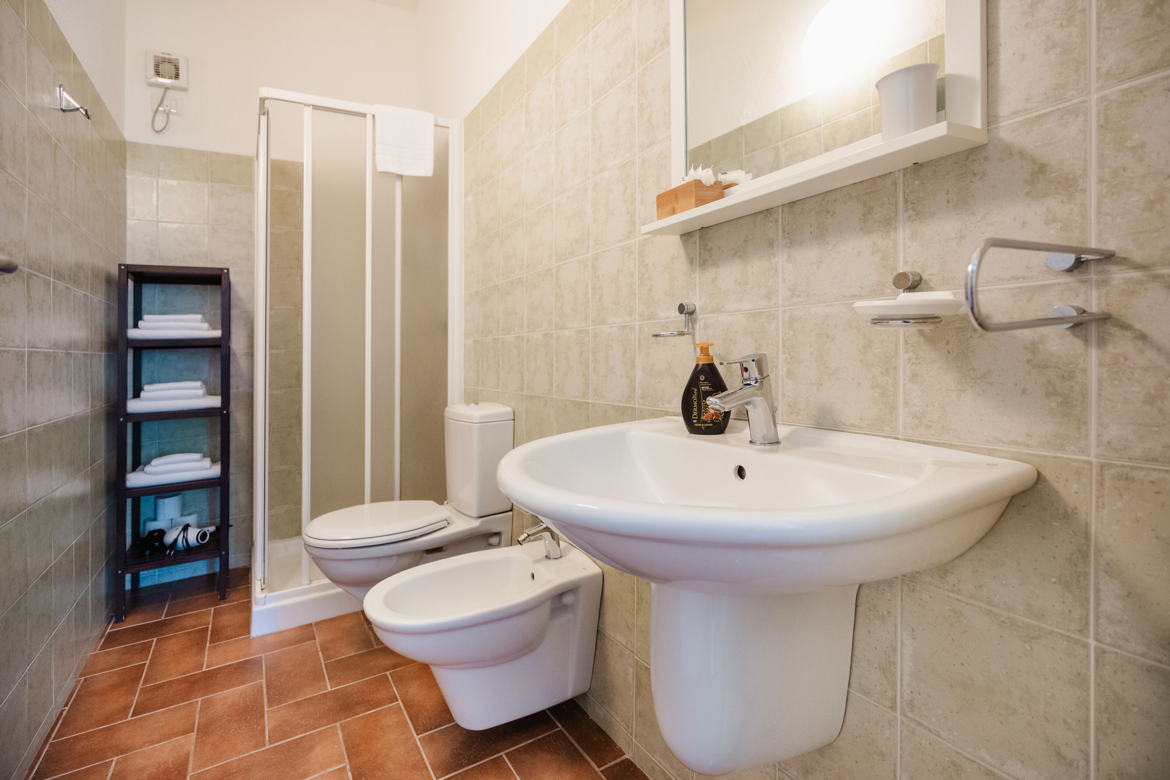 A bathroom with a toilet, bidet, and sink.