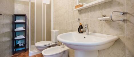 A bathroom with a toilet, bidet, and sink.