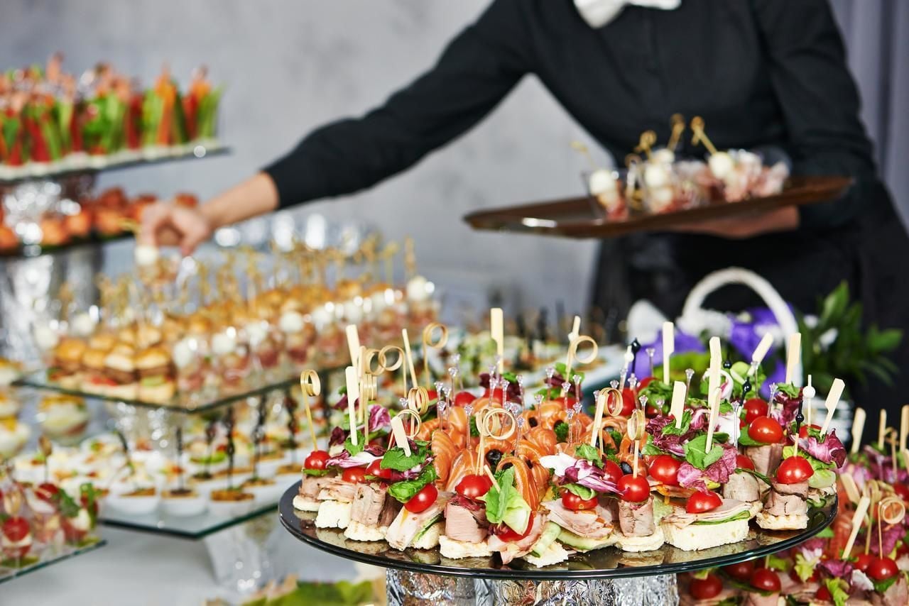 A buffet with various food items and a person serving.