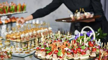 A buffet with various food items and a person serving.