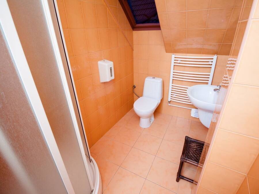 Un bagno piccolo con il water, un lavandino e un asciugamani ad aria.