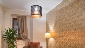En hyggelig stue med sofa, sofabord, lampe og en stueplante.