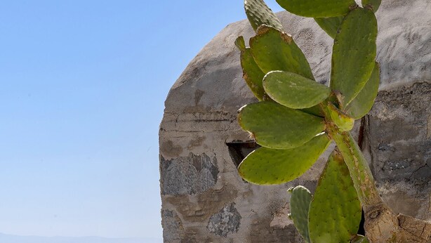 A clear pool with a view of the sea and a rocky structure.