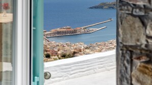 A coastal view from a window overlooking a town and the sea.