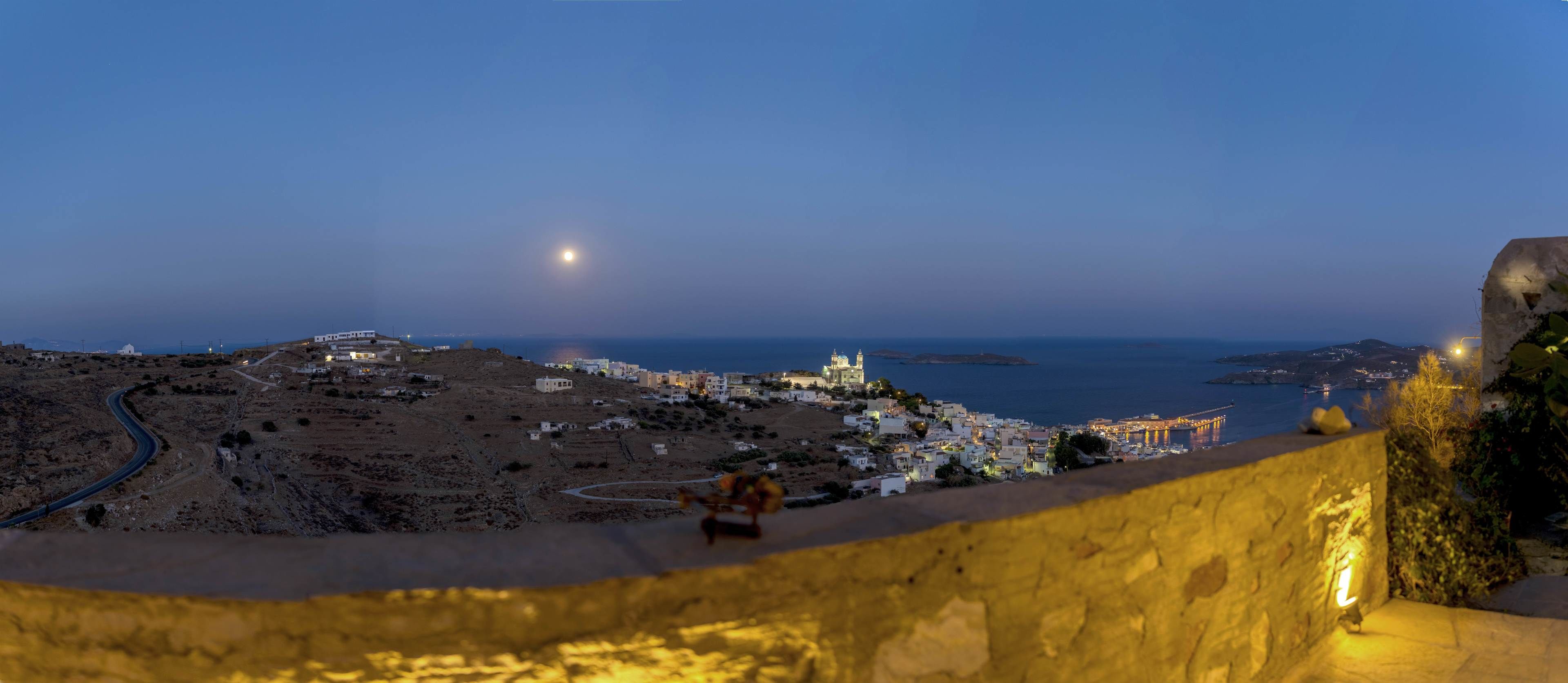 A coastal town at dusk with a prominent church and a winding road.