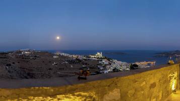 A coastal town at dusk with a prominent church and a winding road.