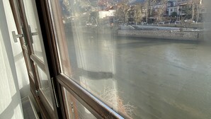 A river view from a window with mountains in the background.