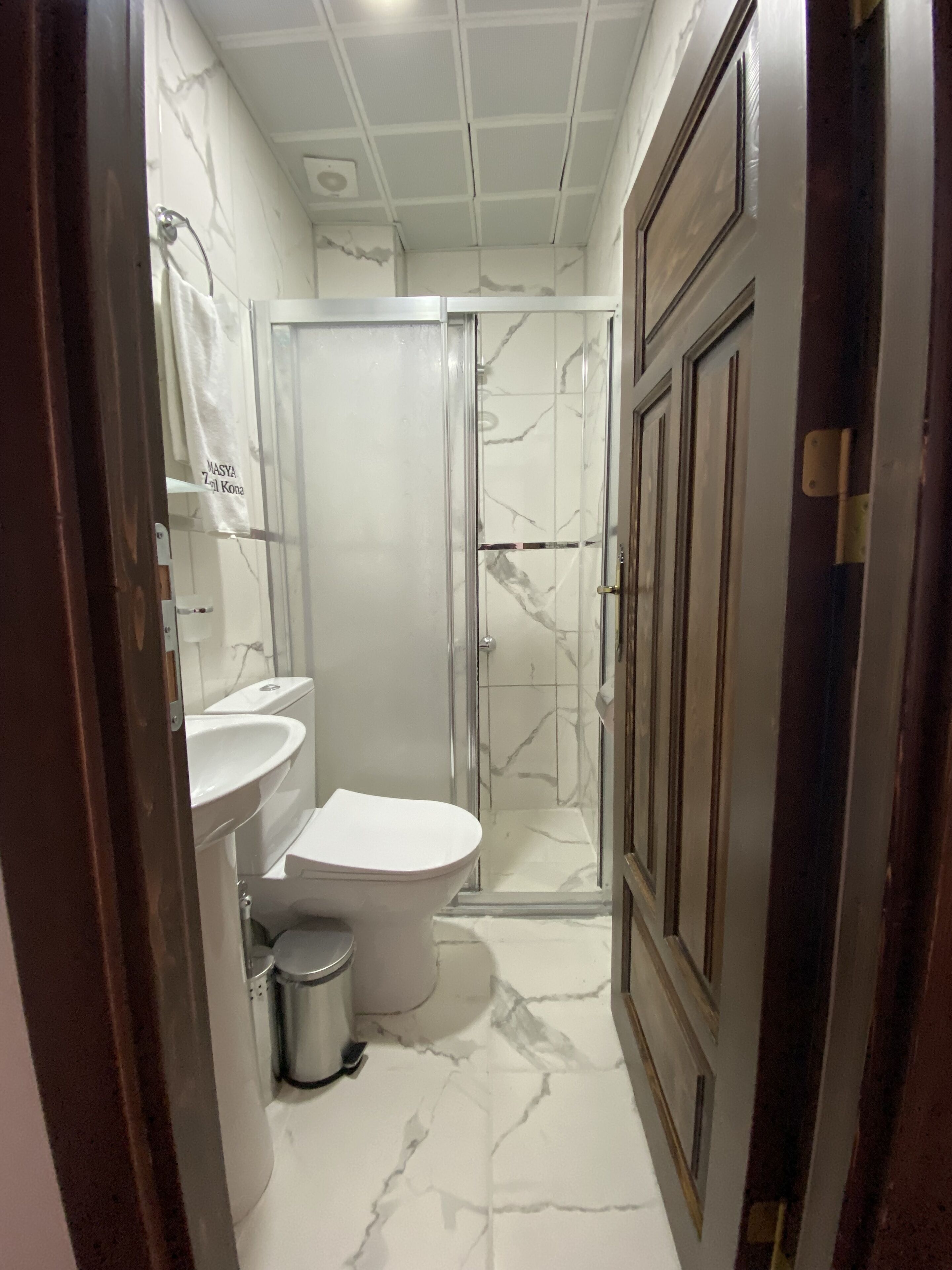 A bathroom with a toilet, sink, and shower.