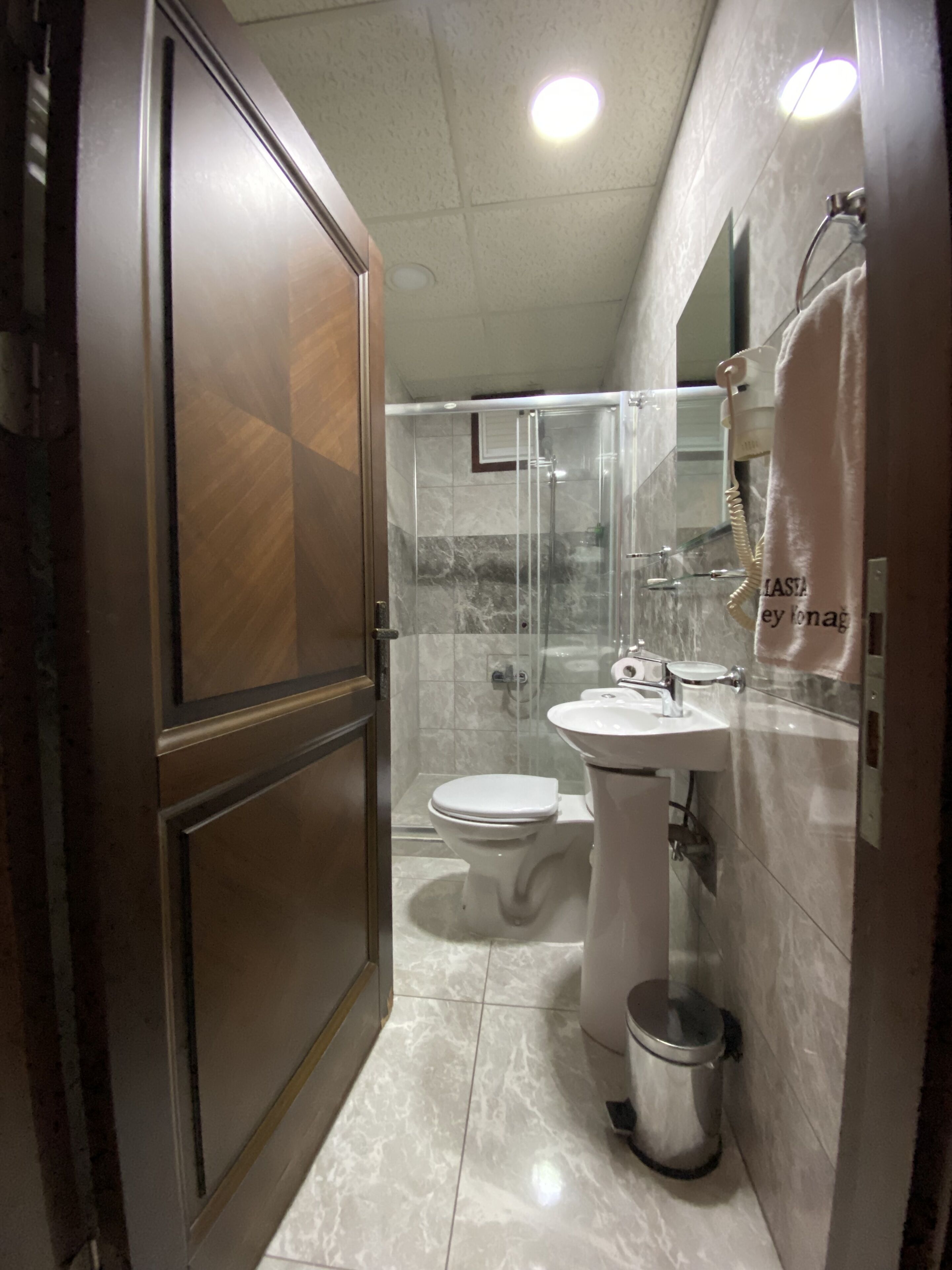 A bathroom with a toilet, sink, and shower area.