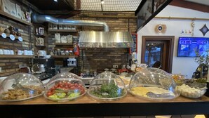 A buffet area with various food items covered in dome-shaped plastic.