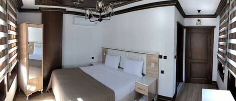 A bedroom with a large bed, a nightstand, a dresser, and a wardrobe.