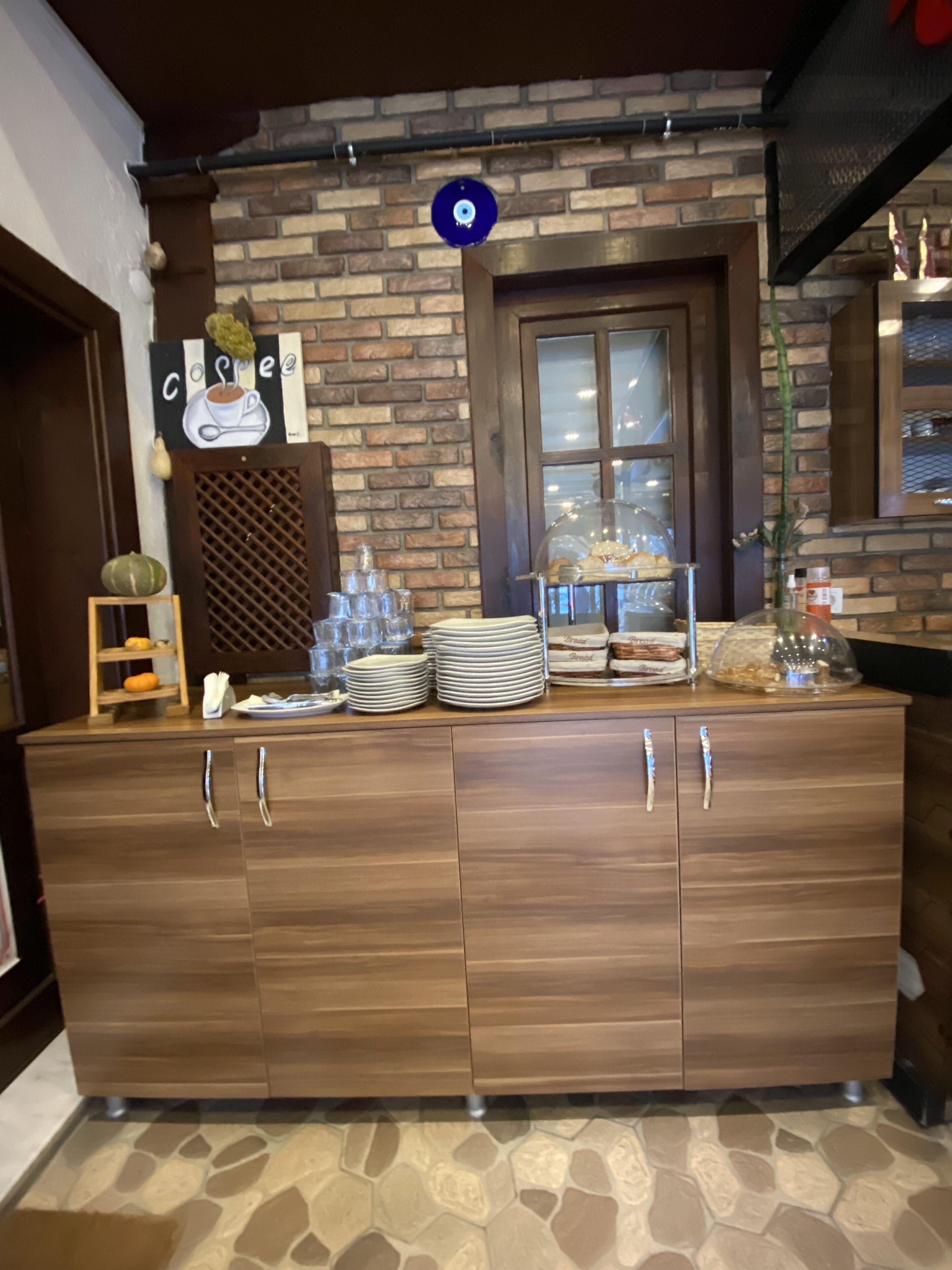Un buffet en bois avec de la vaisselle, des assiettes et du pain.