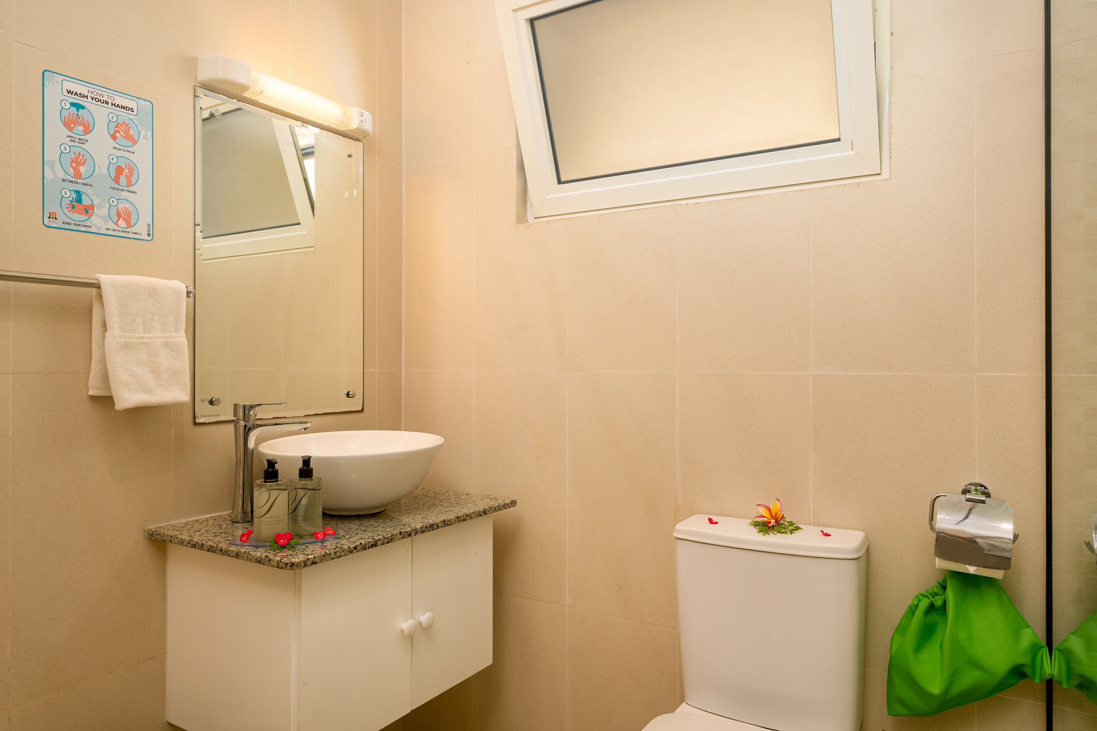 Ein Badezimmer mit Waschbecken, Spiegel und Toilette.