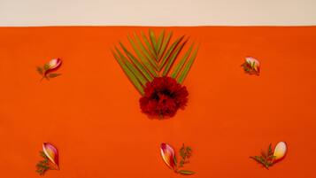 A red flower arrangement on an orange background.