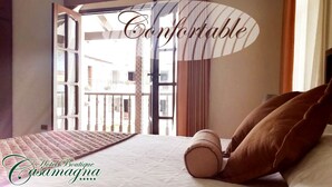 Una habitación de hotel con cama, ventana y vistas al exterior.
