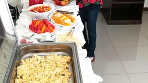 Montaje de bufé con diversos alimentos y un dispensador de bebidas.