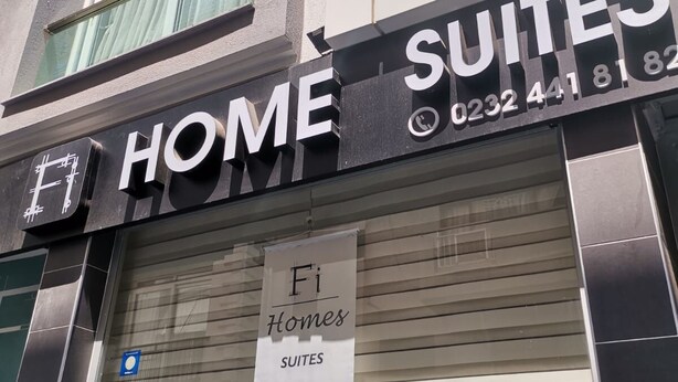 A building with a sign for 'FI Homes Suites' and a banner advertising 'Fi Homes Suites'. - Fi Homes - Adults Only (Izmir)