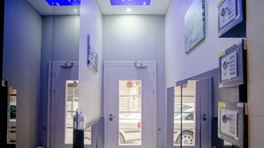 A hallway with a white door, a security keypad, and a view of a parked car outside. - Fi Homes - Adults Only (Izmir)